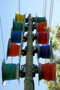 Colourful spools of cable await deployment along a line of utility poles Colourful spools of cable await deployment along a line of utility poles