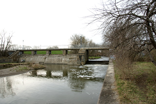 The river still flows through the control structure beside the upper lock. A recreational path crosses along the top