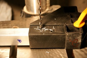 The brackets are already drilled to secure the crosspieces. I drilled out the crosspieces for pop rivets, but if you're using self-tapping screws, you won't need to drill at all.