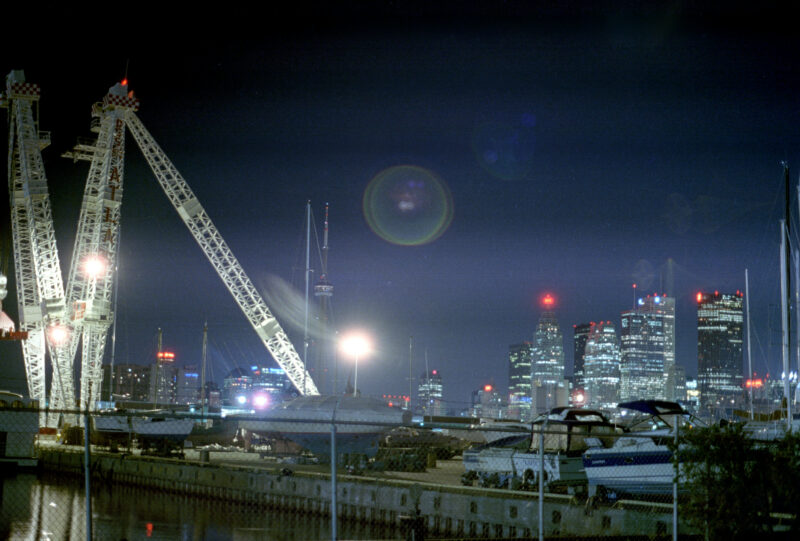 The Atlas Crane in Toronto's port lands as seen in 1999, lit up at night with the downtown skyline in the background